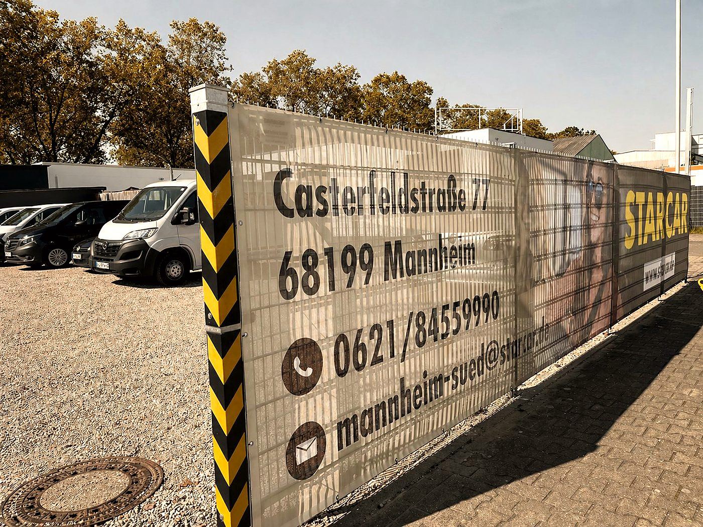 Werbebanner an Bauzaun mit Adresse und Kontaktdaten